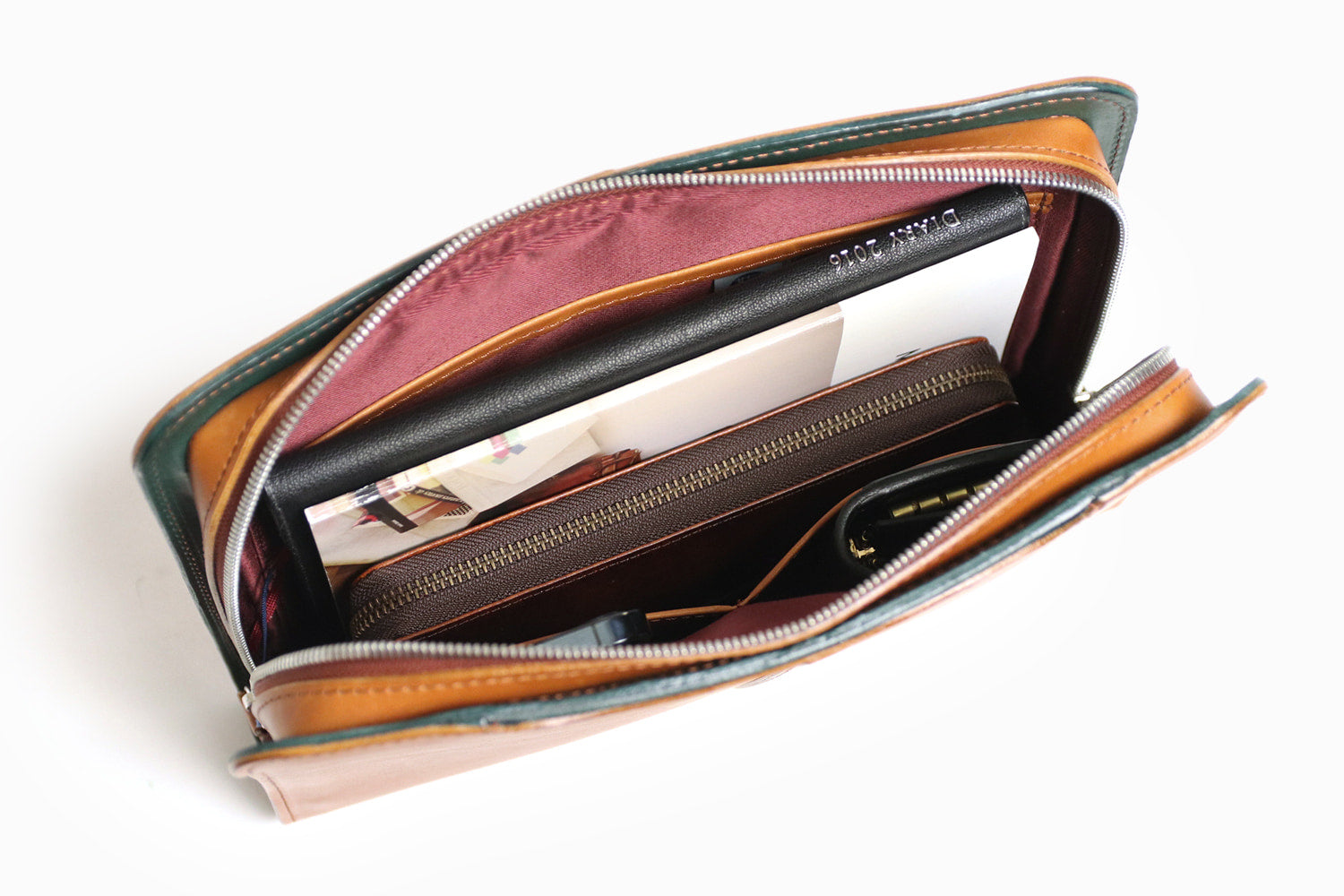 COMPLEX GARDENS / 眼蔵 ゲンゾウ 上質で肉厚なバケッタレザーを贅沢に使用したラウンドジップクラッチバッグ