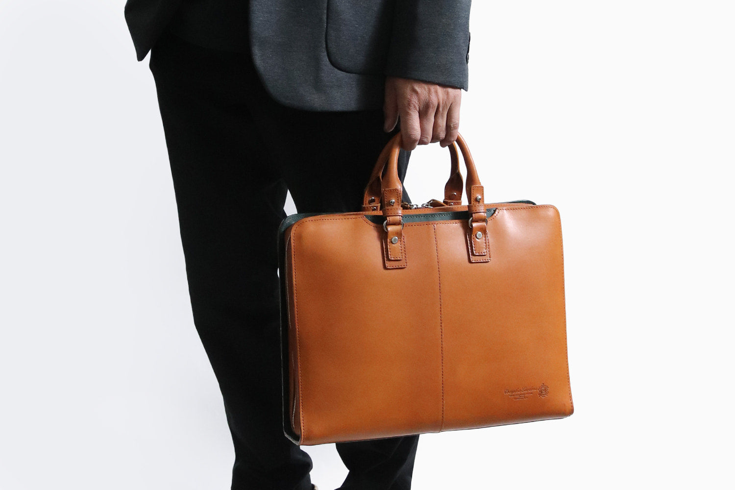 COMPLEX GARDENS / 眼蔵 ゲンゾウ 上質で肉厚なバケッタレザーを贅沢に使用したラウンドジップB4ブリーフケース