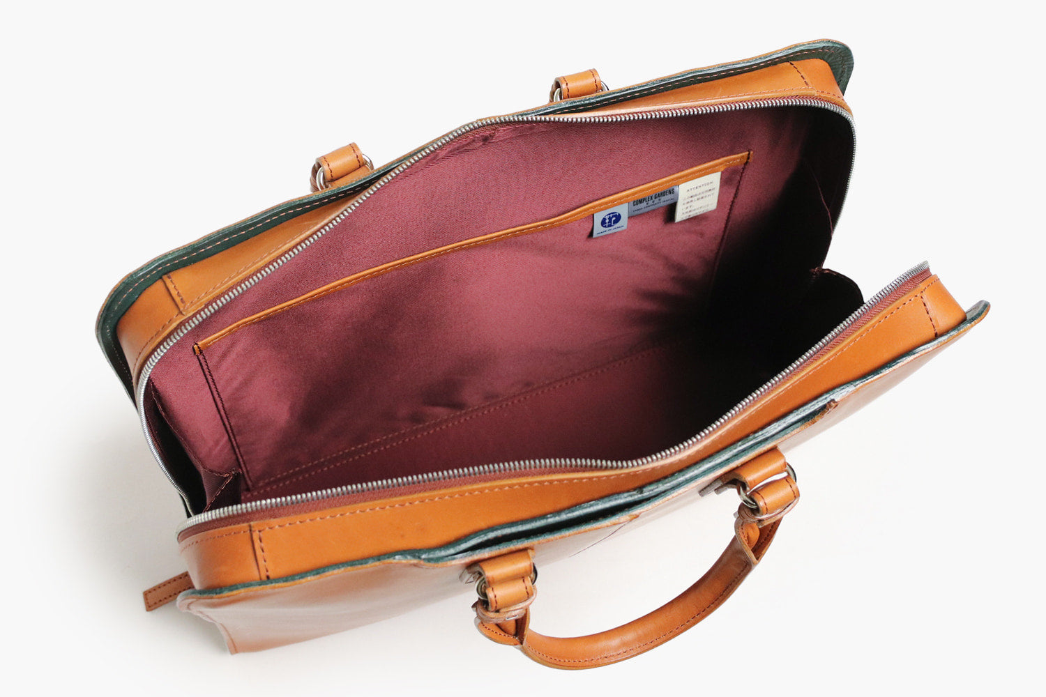 COMPLEX GARDENS / 眼蔵 ゲンゾウ  上質で肉厚なバケッタレザーを贅沢に使用したラウンドジップB4ブリーフケース