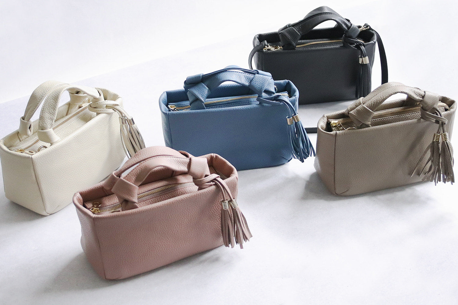 Atelier nuu / loop Gentle tones and soft Italian leather. Mini Boston bag with dangling tassels 